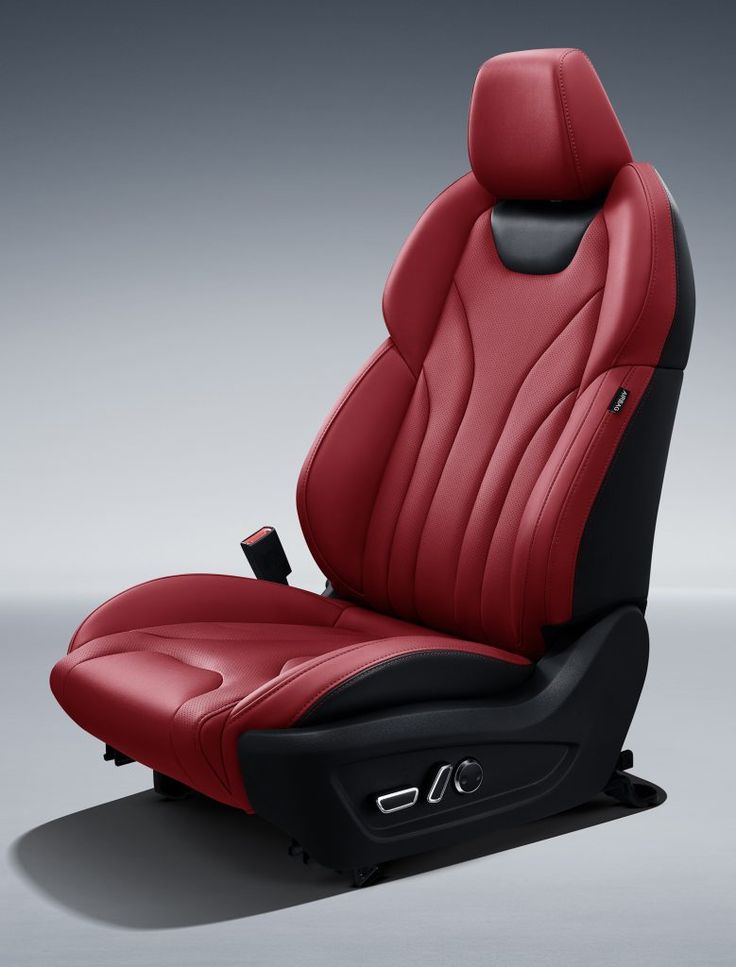 a red and black leather car seat on a gray background with the head rest facing forward