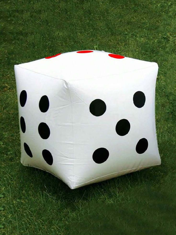 a white and black dice sitting in the grass