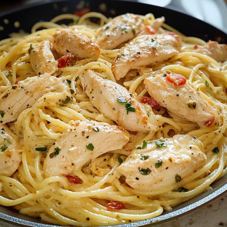 a skillet filled with chicken and pasta