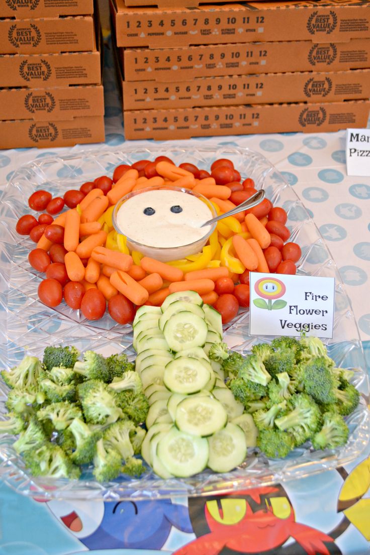 a table topped with lots of veggies next to boxes of carrots and broccoli