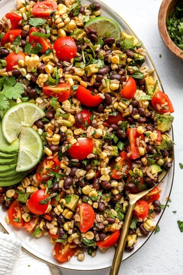 a salad with black beans, tomatoes, corn and avocado on a plate