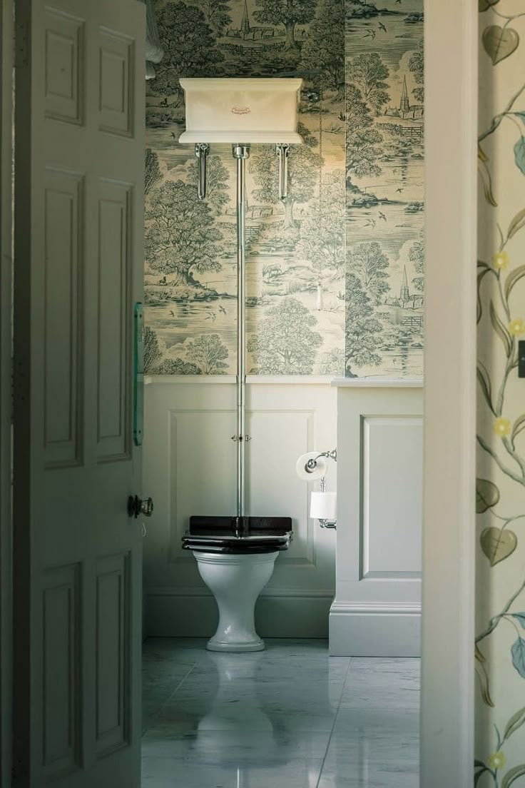 an open door leading to a bathroom with a toilet and wallpaper on the walls