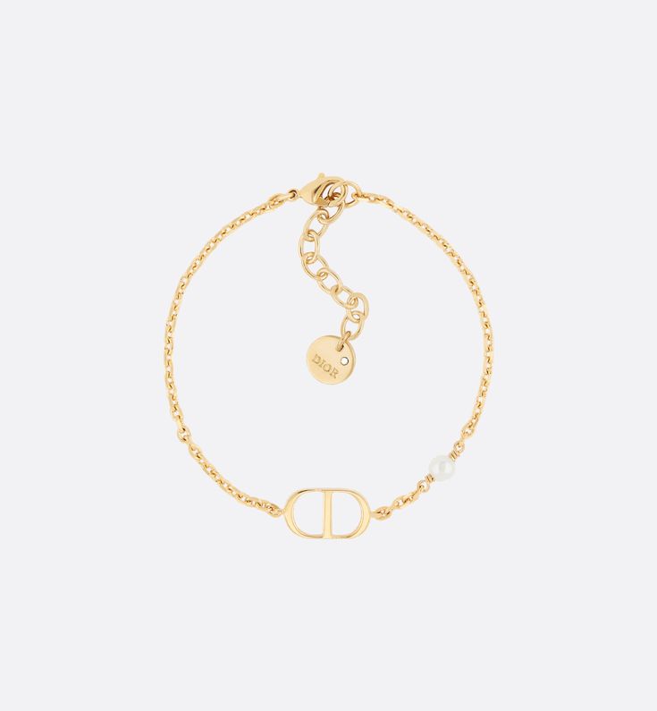 The Petit CD bracelet has an elegant and streamlined aesthetic. The style is comprised of a thin gold-finish metal chain showcasing a 'CD' signature at the center. A small white resin pearl completes the look. Modern and refined, the bracelet may be worn with other Petit CD creations.. Bracelet Cd, Dior Bracelet Gold, Cd Bracelet, Bracelet Dior, Christian Dior Jewelry, Christian Dior Bracelet, Dior Bracelet, 24 Birthday, Dream Items