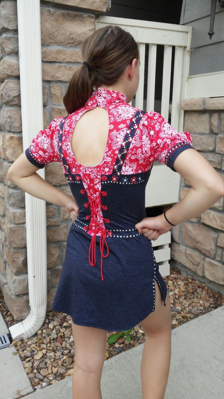 a woman in a short skirt is standing on the sidewalk with her back to the camera