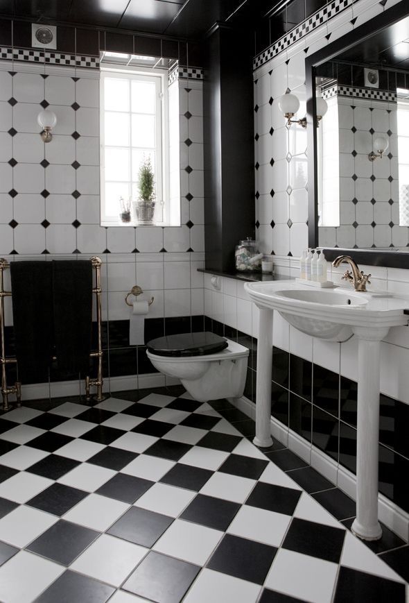 a black and white bathroom with checkered flooring