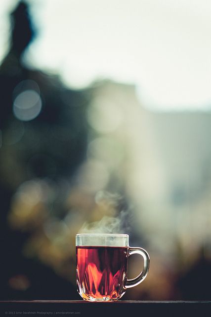 a cup of hot tea with steam rising from it