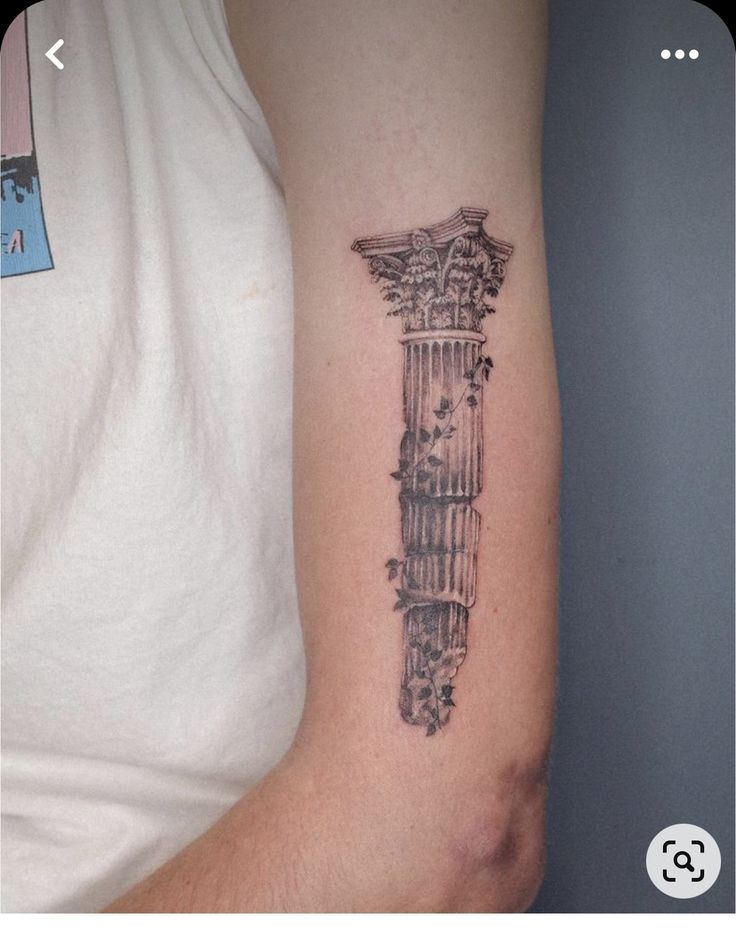 a man with a tattoo on his arm that has an image of a column in the middle