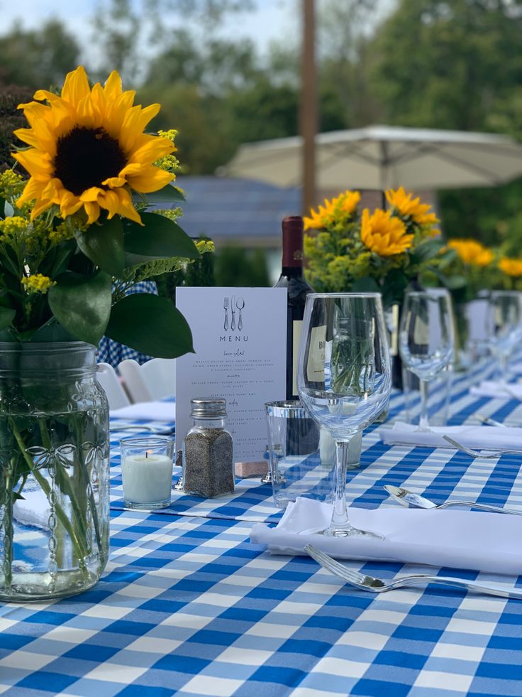 the table is set with sunflowers and empty wine glasses for guests to enjoy