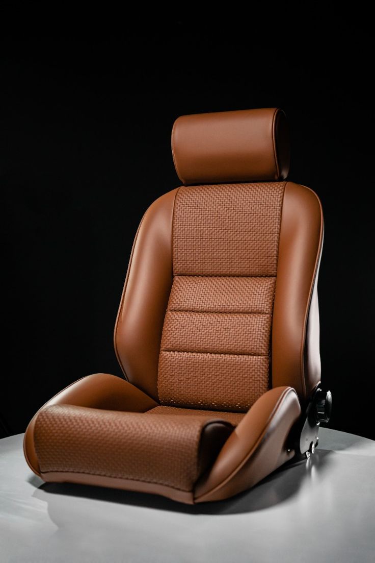 a brown leather chair sitting on top of a white table