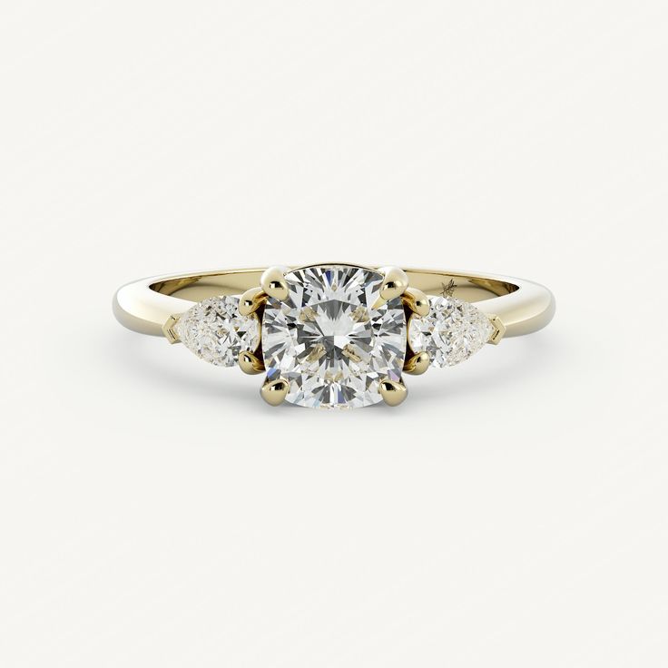 a three stone engagement ring with an oval diamond center and side stones in yellow gold