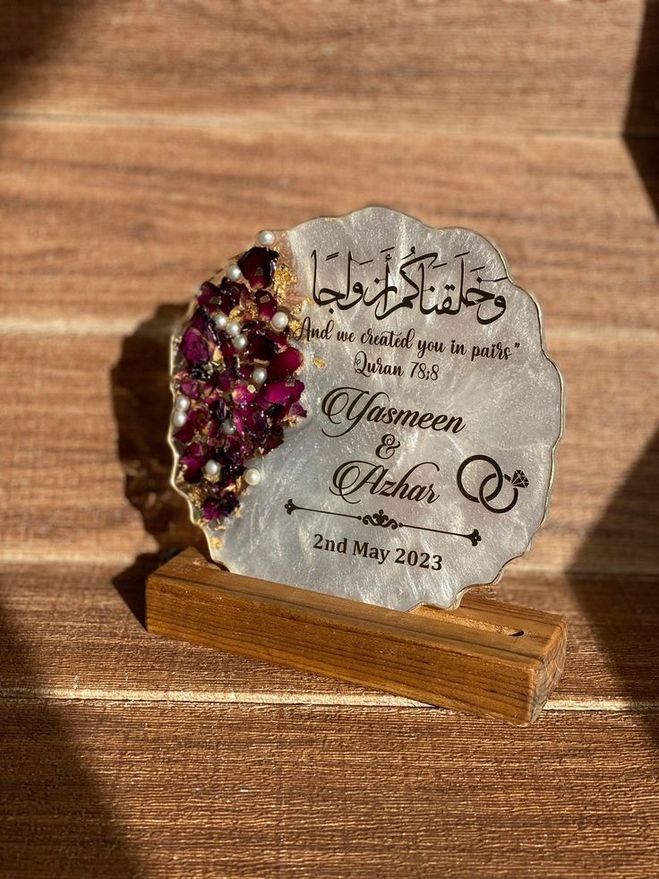 a wedding ornament is sitting on a wooden stand with the name of the couple