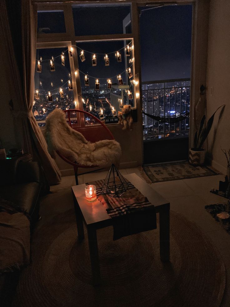 a living room filled with furniture next to a window covered in christmas lights at night