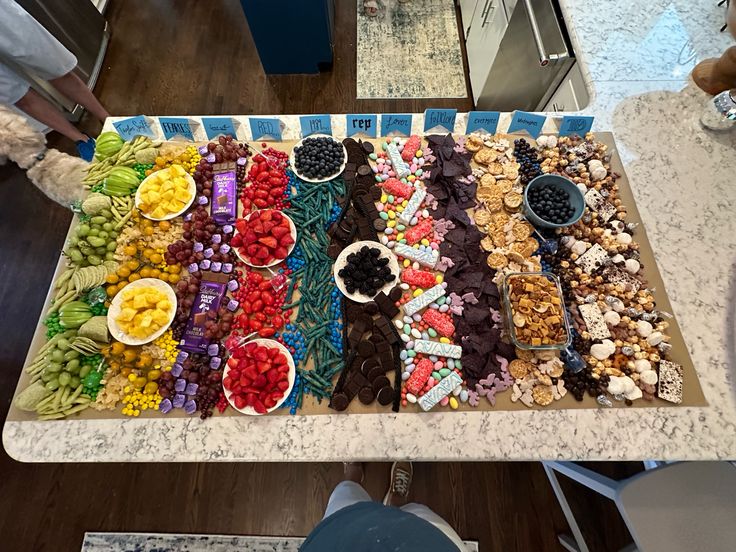 a table topped with lots of different types of candies and fruit on top of it