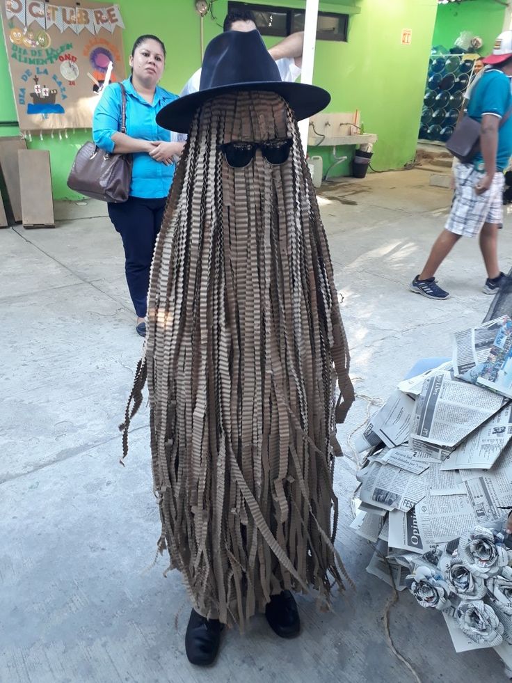 a woman wearing a costume made to look like a man with dreadlocks and a hat