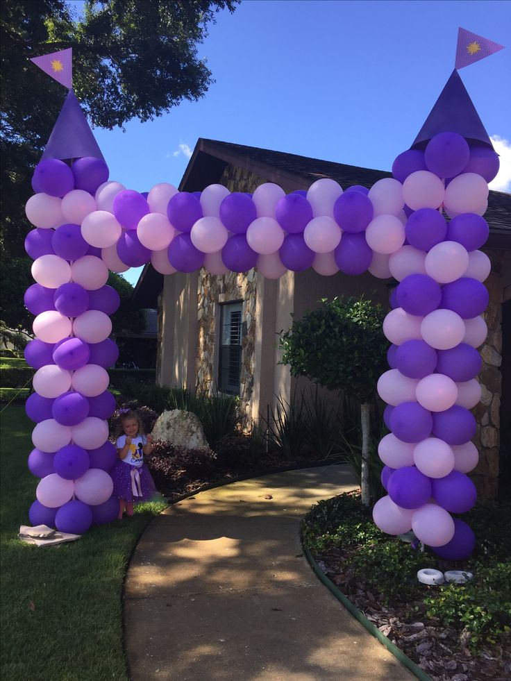 a purple and white arch decorated with balloons