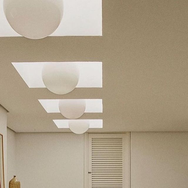 an empty room with white walls and ceiling lights