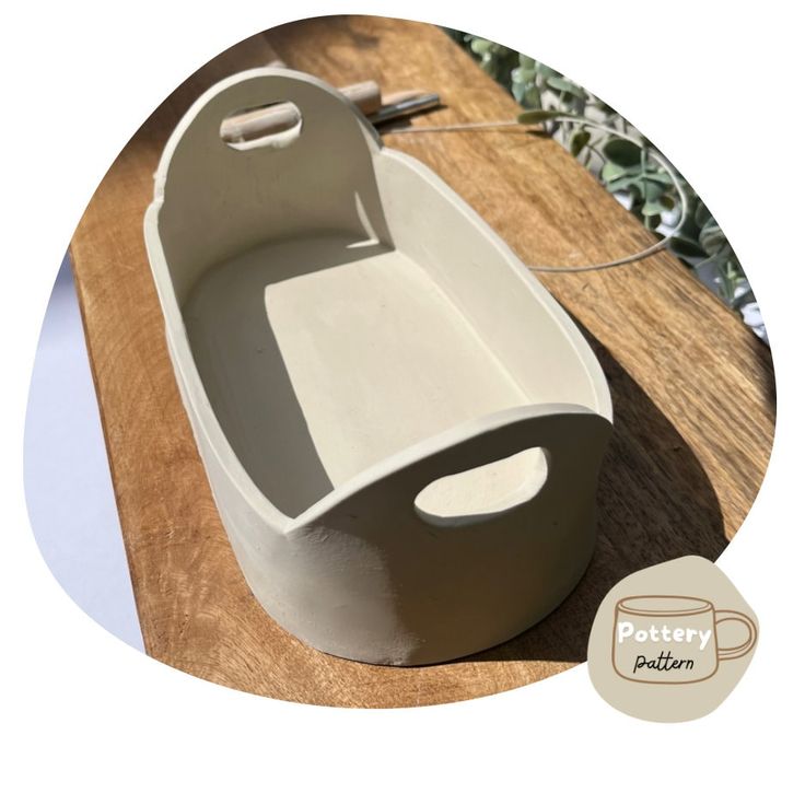 a white bathtub sitting on top of a wooden table next to a potted plant