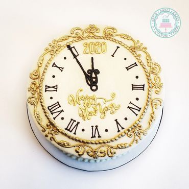 a white and gold cake with a clock on it