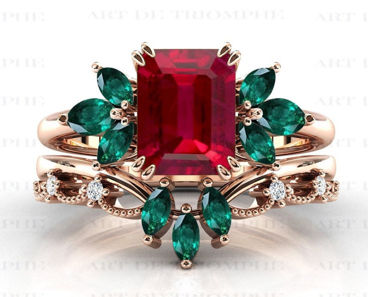 an emerald and red stone ring set with green leaves on the band, surrounded by white diamonds