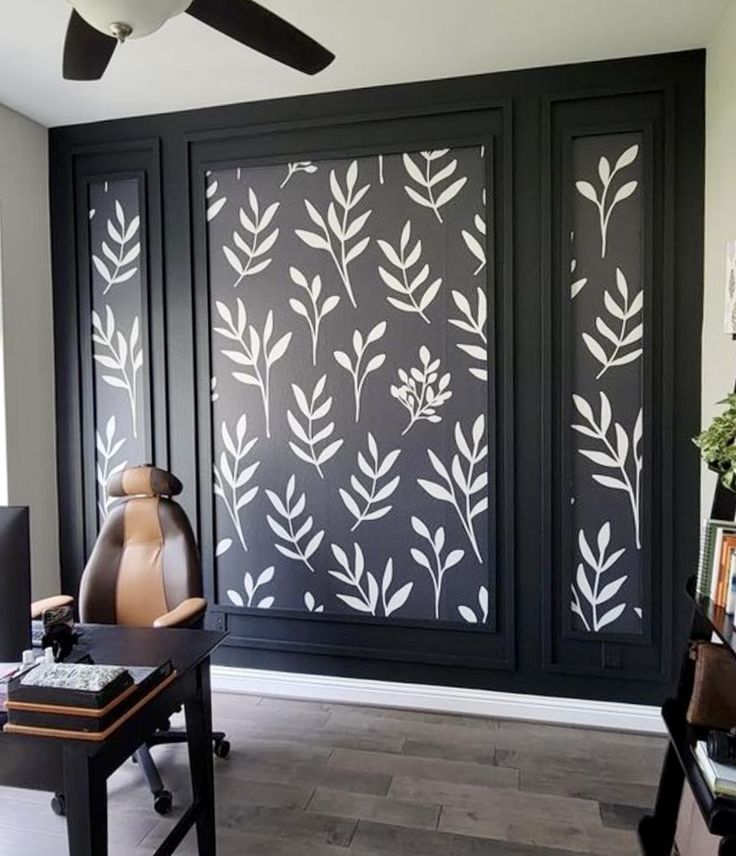 a living room with black and white wallpaper on the walls next to a desk