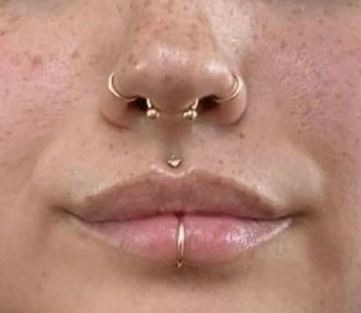 a woman's nose with two piercings on her nose and one in the middle