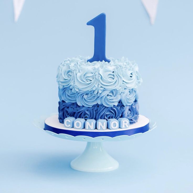 a blue and white cake with the number one on it