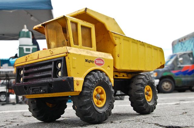 a yellow toy truck sitting on top of a parking lot