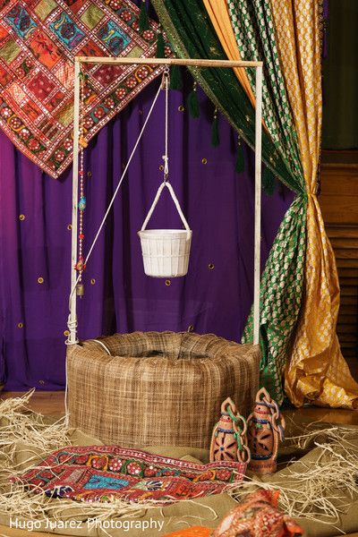 a bed with a basket hanging from it's side and other items on the floor