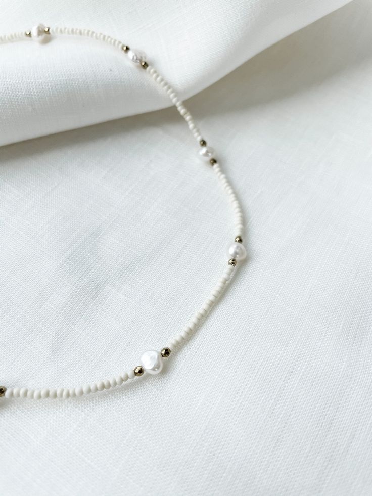 "Ivory seed beads with natural pearls and 3mm faceted hematite spacers. Necklace had lobster clasp closure with 2\" adjustable chain. Each piece is designed and handmade in Brooklyn. After visiting the Notre Maison orphanage in 2015, I fell in love with the children and knew I wanted to help sponsor them. That's what started this shop. Every purchase helps us sponsor 5 children at the orphanage that we follow up with and visit over the summers. Join our Ubuntu family so that together we can be t White Pearl Jewelry With Faceted Beads, Adjustable Pearl Beaded Necklace With Faceted Beads, Beige Beaded Necklaces With Round Beads, Beige Beaded Necklace With Round Beads, White Pearl Beaded Chain Jewelry, White Beaded Necklace With Round Beads, Pearl White Necklaces With Faceted Beads, Pearl White Beaded Necklaces With Round Beads, White Pearl Jewelry With Beaded Chain