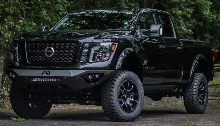 a black truck is parked in front of some trees