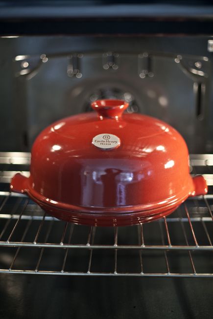 an orange pot is cooking in the oven