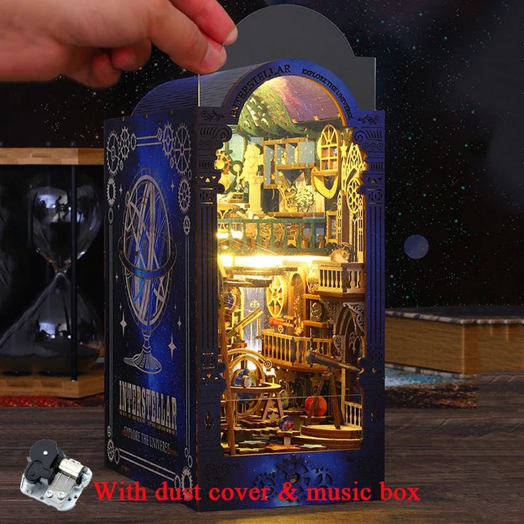 a hand is opening the door to a musical box with an image of a clock on it