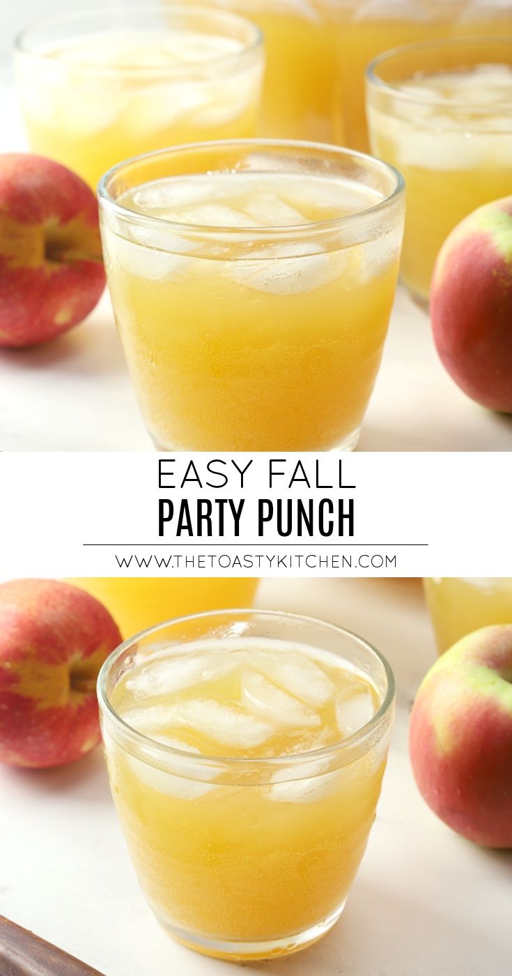 two glasses filled with peach punch on top of a white table next to some apples