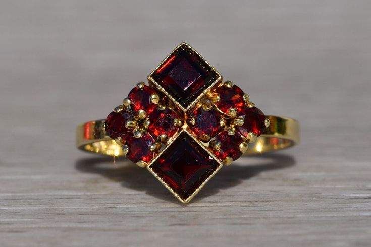 The Amwell: Ladies Signed 14K Mid Century Cocktail Ring set with Garnet. Crafted in 14 karat yellow gold is this vintage mid century styled ring set throughout with garnets. From North to South, you will see two square emerald cut garnets bezel set and decorated with fine milgrain. To the left and right are four round cut diamonds on either side. Currently the ring is a finger size 6.5 and is able to be resized for an additional fee upon request. Ruby Engagement Ring, Yellow Gold Chain, Beaded Hoops, Garnet Rings, Pendant Rings, Jewelry Inspo, Dream Jewelry, Vintage Ring, Fine Jewellery