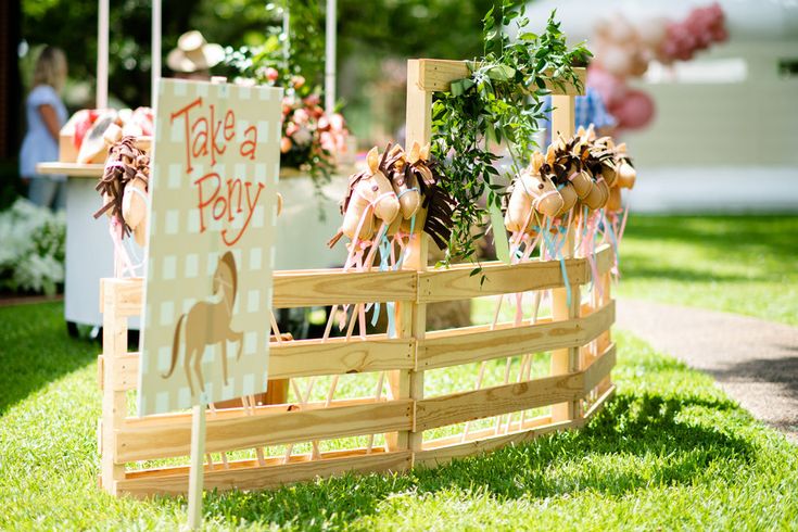 a sign that says take a baby next to some plants in a wooden box on the grass