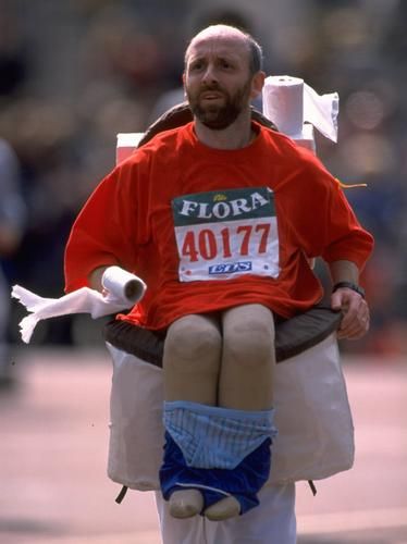 a man sitting on top of a giant toilet in the middle of a race track