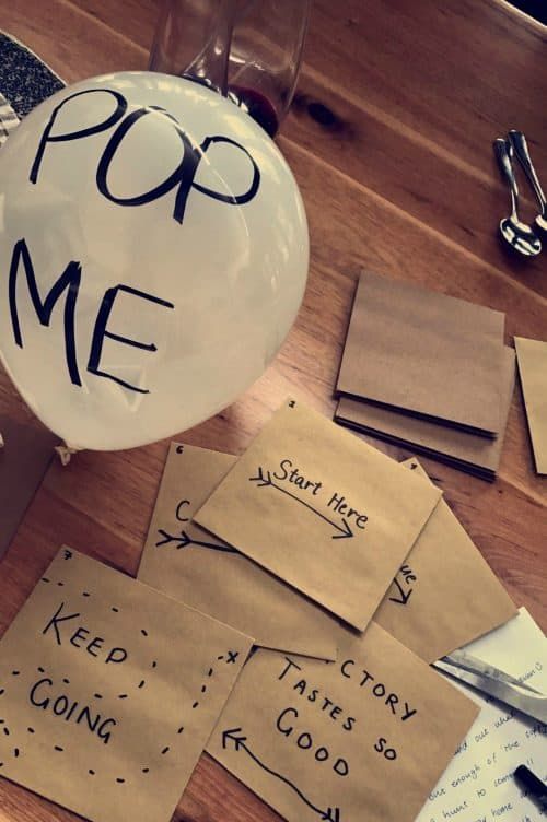 a table topped with lots of papers and balloons that say pop me on them,