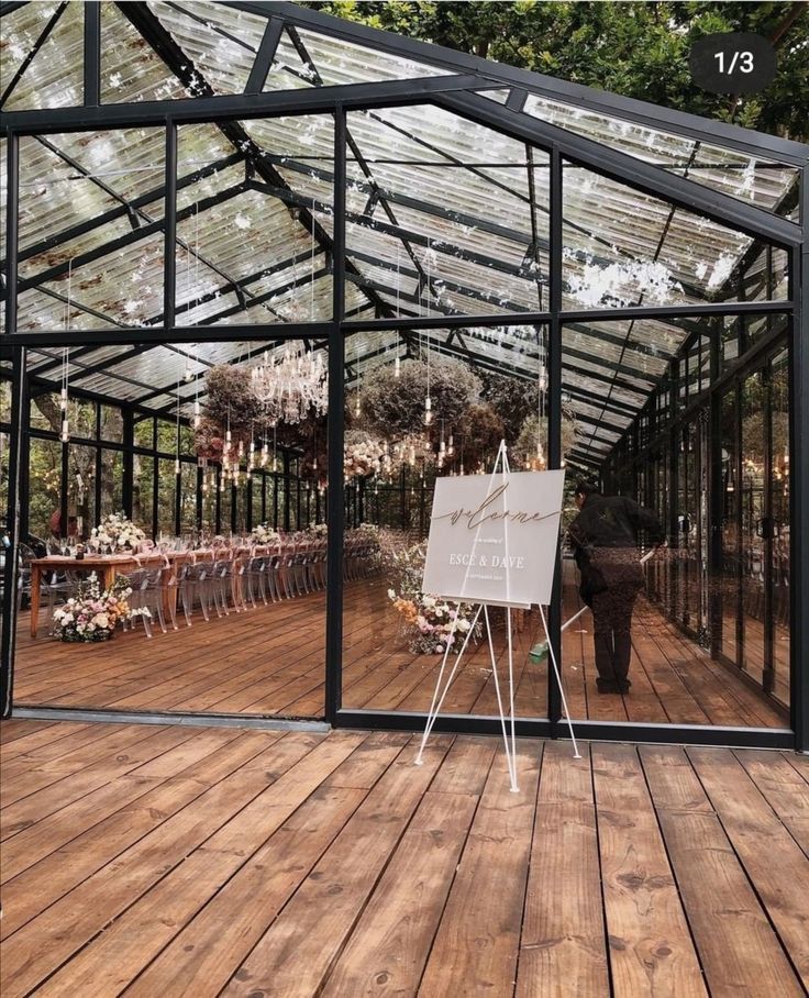 a large glass greenhouse with tables and chairs in it