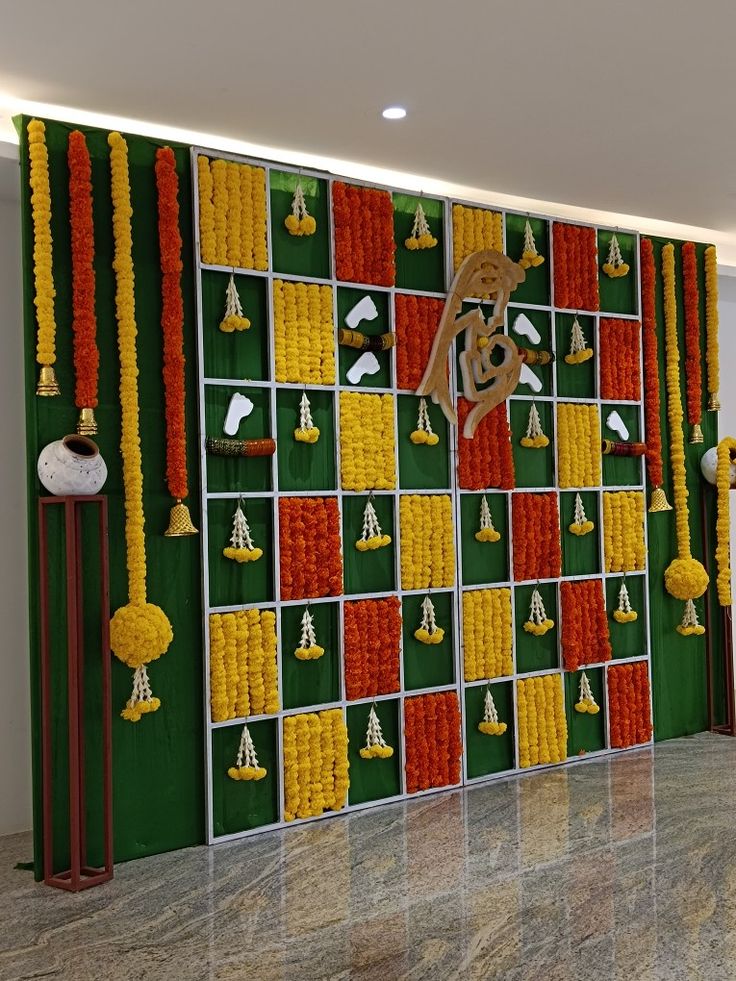 the wall is decorated with flowers and gold bells on it, along with other decorations