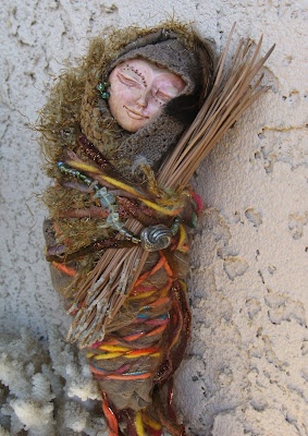 a doll is laying on the ground next to some twigs and grass with her eyes closed