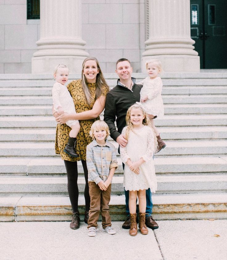 a family poses for a photo in front of the steps of an old courthouse building