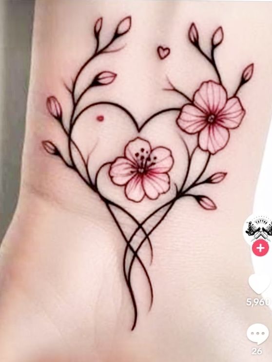 a heart shaped tattoo with pink flowers on the side of the foot and hearts in the middle