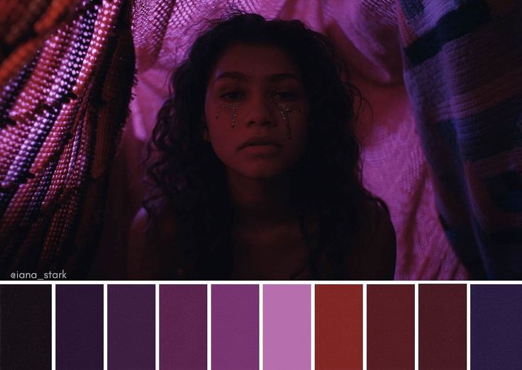 a woman laying on top of a bed in front of a purple and red color scheme