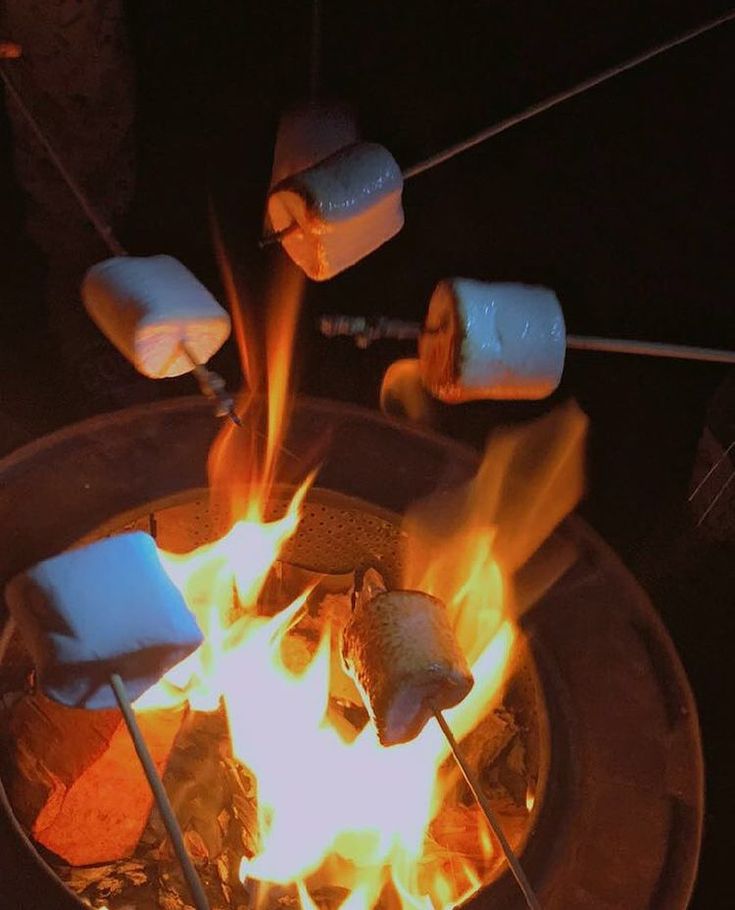 marshmallows roasting over an open fire pit