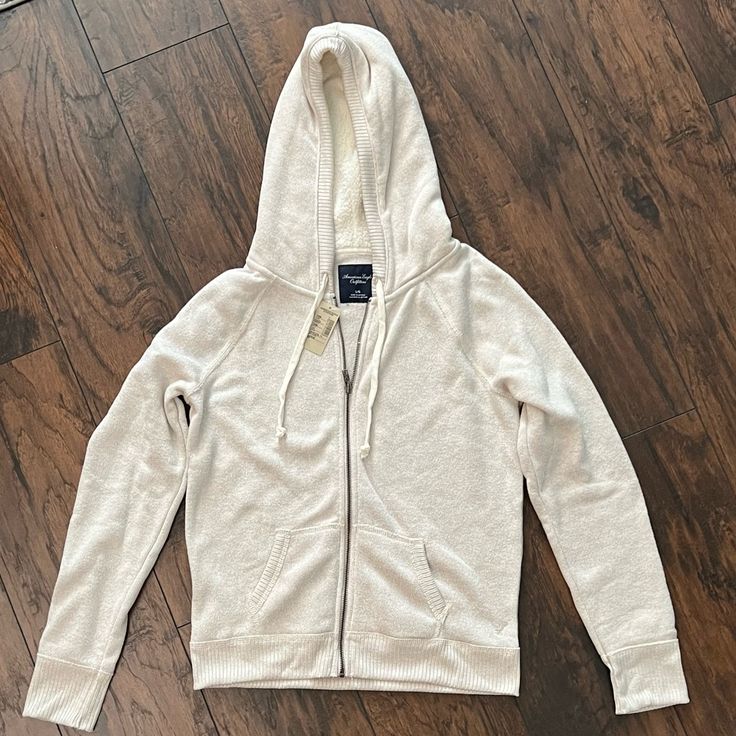 American Eagle Outfitters Hooded Zip Up Jacket. Size Large. New With Tags. Light Oatmeal/ Cream Color. Cozy Beige Hoodie With Double-lined Hood, Cream Cozy Hoodie With Double-lined Hood, Cozy Cream Hoodie With Double-lined Hood, Casual Winter White Outerwear With Double-lined Hood, Casual Winter White Hooded Jacket With Double-lined Hood, Cozy Cream Hoodie With Pockets, Casual Hooded Jacket With Fleece Lining For Loungewear, Beige Hooded Everyday Outerwear, Cozy Cream Hooded Jacket For Winter