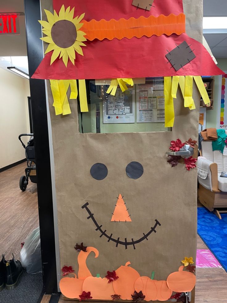 a brown paper bag with a scarecrow face on it and decorations around the top