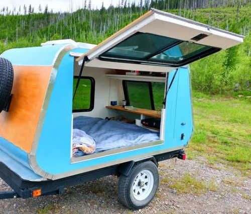 a small camper trailer with a bed in the back