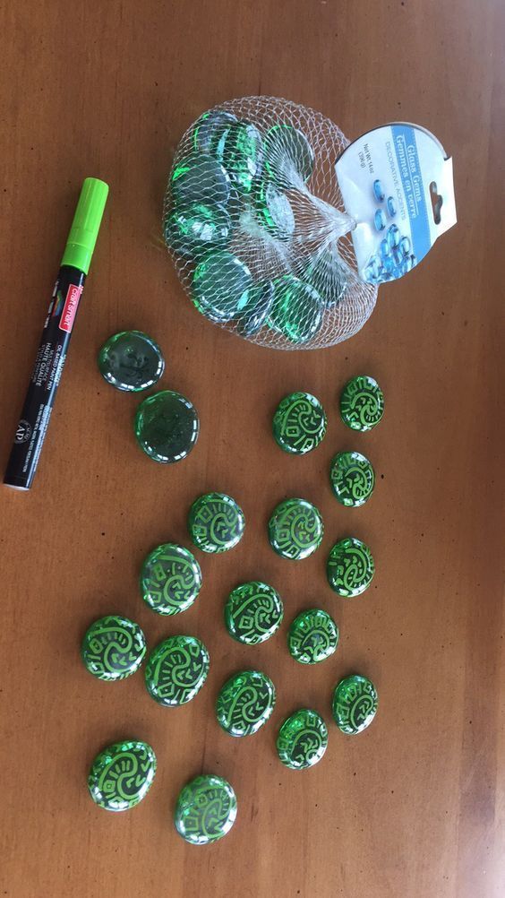 there are many green candies on the table next to a marker and some pens