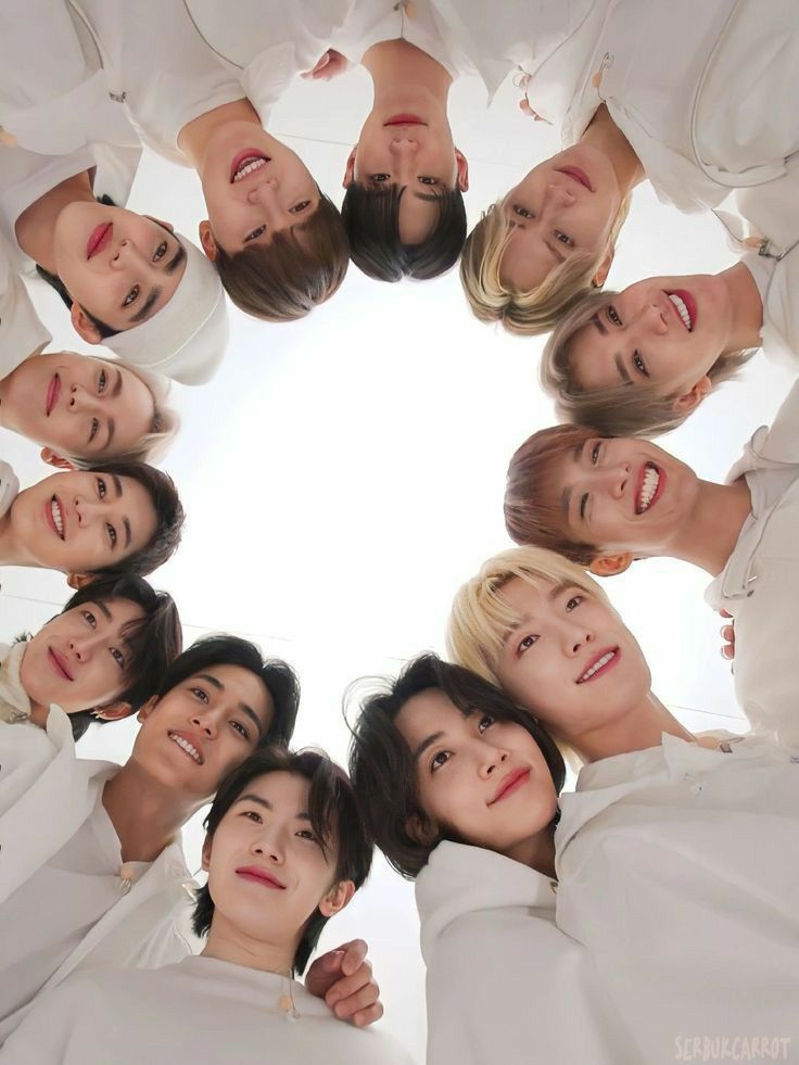 a group of young people standing in a circle looking up at the camera with smiles on their faces