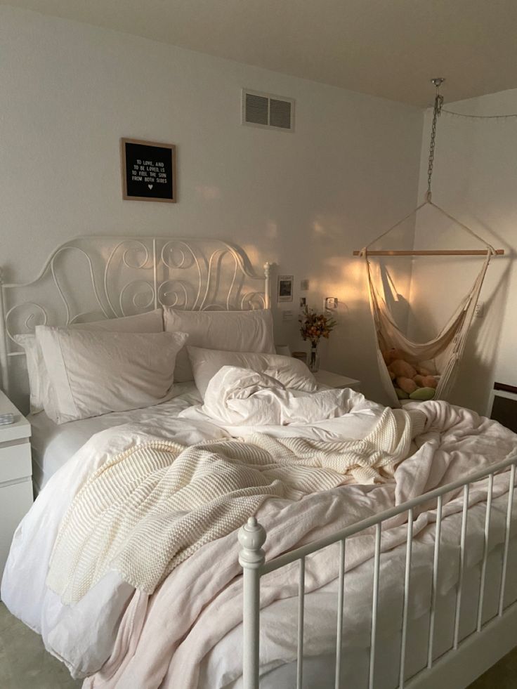 a white bed sitting in a bedroom next to a window